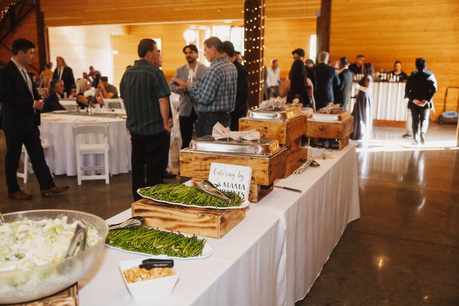 Catered buffet line inside the barn with guests mingling