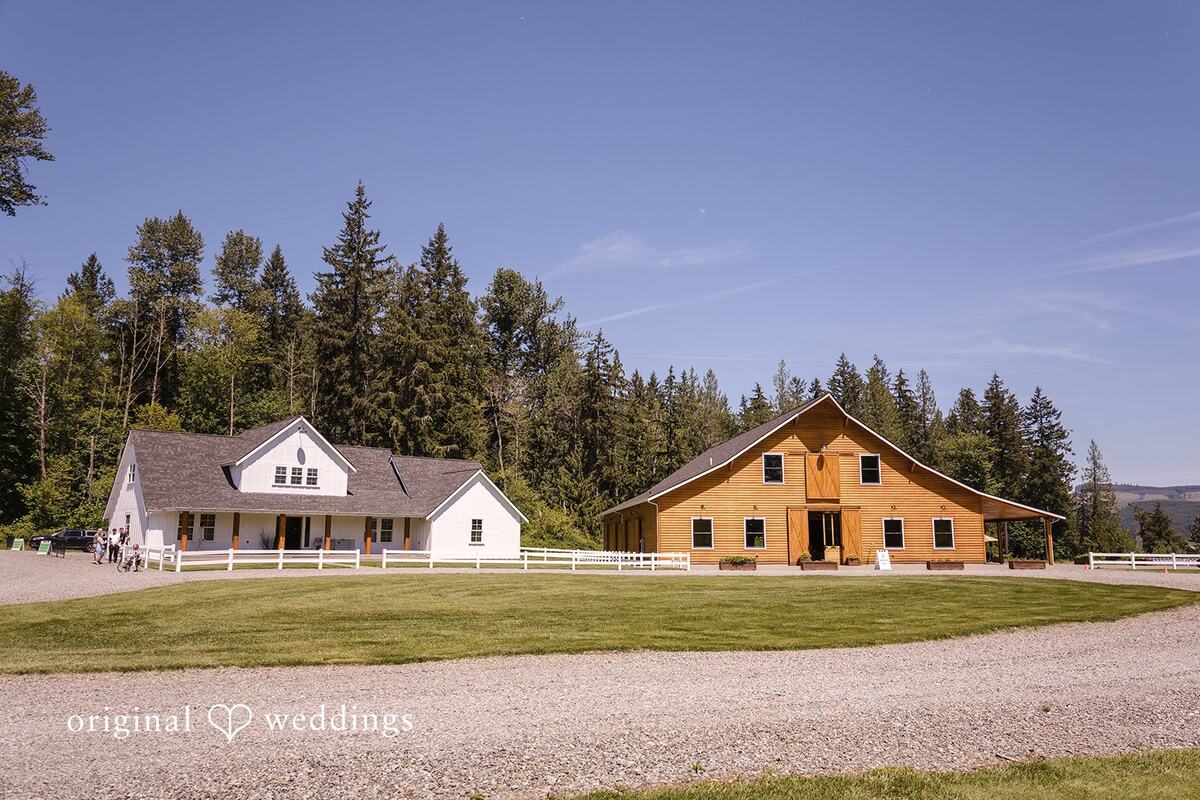 The white bridal cottage and the cedar barn side by side on the lawn